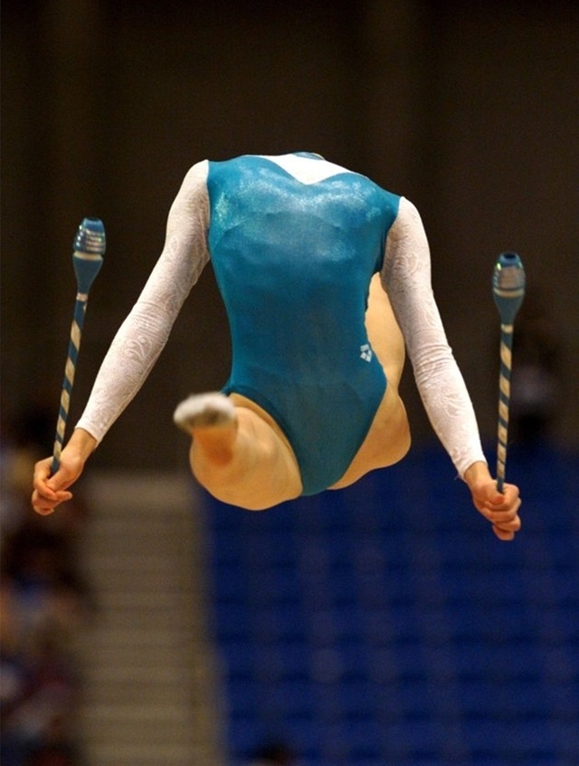 This gymnast isn’t handicapped neither she lost her head. This is a mid-jump photo. Her head is bent backwards. 