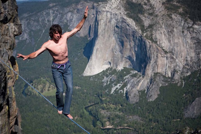 He is Dean Potter, American free climber walking on a Highline without any safety equipment over the mountain. 